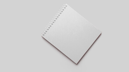 Empty white notebook mockup with soft shadows on neutral grey concrete background.