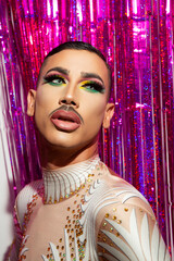 young man makeup drag queen performer with colorful background