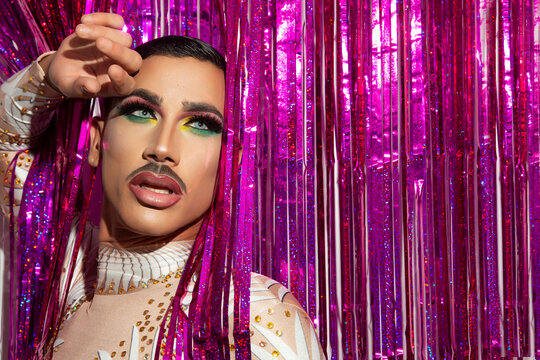 young man makeup drag queen performer with colorful background