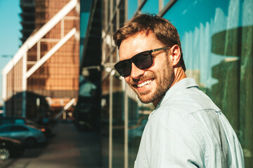 Portrait of handsome smiling stylish hipster lambersexual model.Modern man dressed in blue shirt....