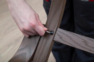 Furniture assembly.An employee collects furniture using a special tool.