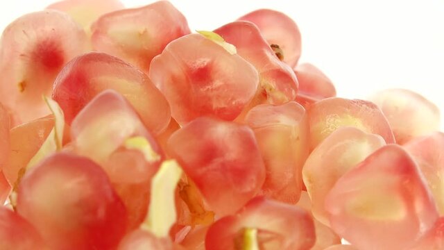 4K Organic healthy red fruit close-up. Open pomegranate fruit rotates on a white  background. Pomegranate seeds.