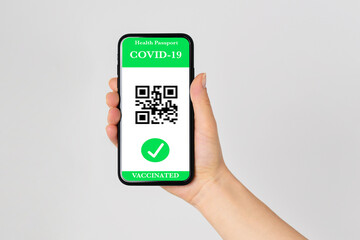 Vaccinated person holding mobile phone with digital health passport for travel during covid-19 pandemic. Green certificate