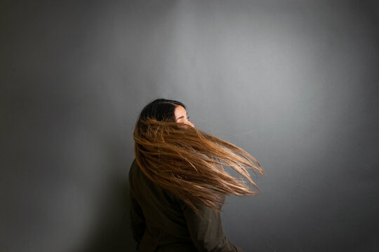 creative portrait of beautiful mexican woman blowing her hair