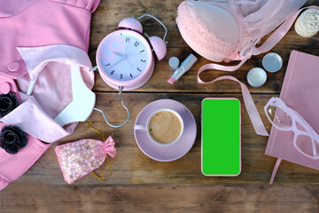 womens stylish accessories, smartphone with blank screen, glamorous set in pink shades, flat lay, copy background, womens clothing, alarm clock, lipstick, coffee cup, good morning concept, female life