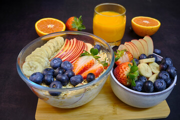 Healthy breakfast with fresh fruits and juice. Bowl of colorful fruits and oats.