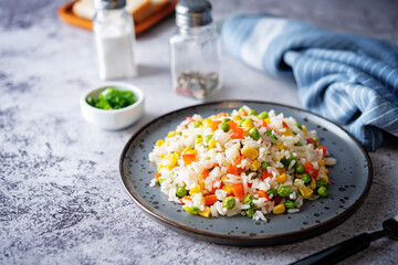 Corn green peas red pepper rice in a plate