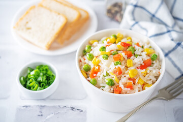 Corn green peas red pepper rice in a plate