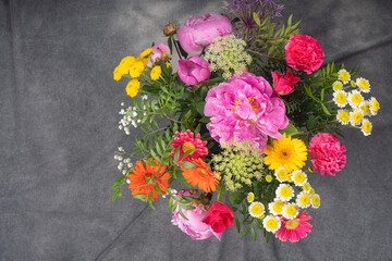 A large and beautiful bouquet with peonies, roses, view from the top, on a dark background. Congratulation concept.
