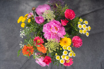 A large and beautiful bouquet with peonies, roses, view from the top, on a dark background. Congratulation concept.