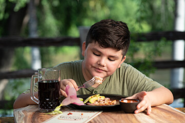 Niño latinoamericano, mexicano, sinaloense comiendo mariscos tostada de camaron acompañado con...