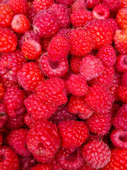 Raspberry background. Fresh, juicy, red berries of ripe raspberries lie one on one creating a beautiful natural and delicious background, use for wallpaper, close-up top view