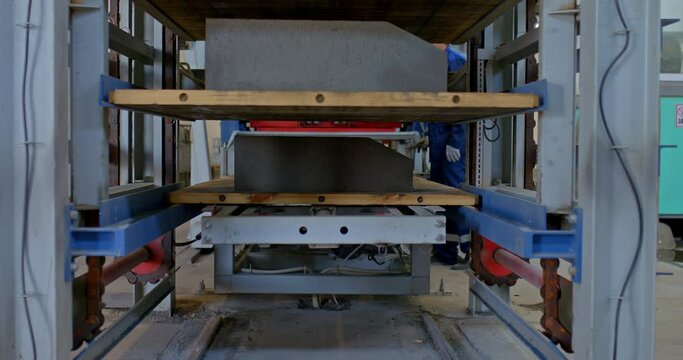 Close-up, an automated stacker lifts the concrete parts of the side. Modern logistics in production, factory warehouses. 4k, ProRes