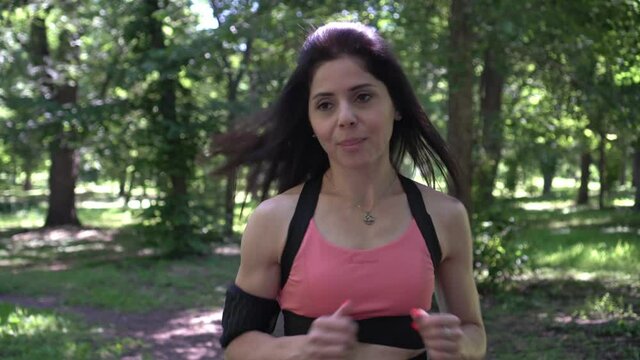 Woman runner goes in for sports and jogging outdoors. Athletic woman exercising and running in the park