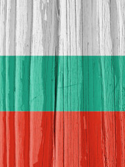 Fragment of the flag of Bulgaria on dry cracked wooden surface. It seems to flutter in the wind. Vertical bright illustration with Bulgarian national symbol. Hard sunlight with shadows on old wood