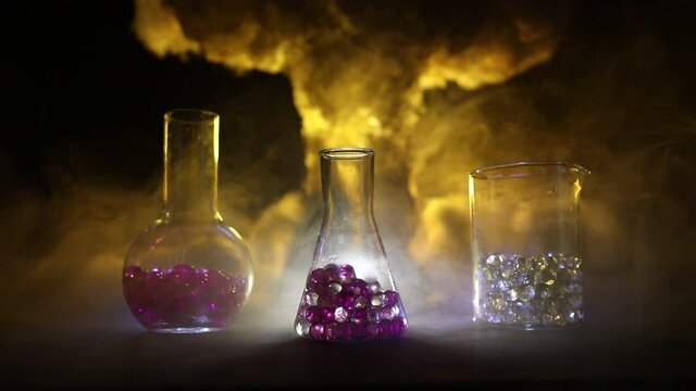 Pharmacy and chemistry theme. Test glass flask with solution in research laboratory. Science and medical background. Laboratory test tubes on abstract explosion cloud background. Selective focus