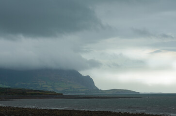 Stormy seascape, Trefor, north Wales. Dramatic  skies with  clouds around the coastal mountains of the beautiful Llyn peninsula.  Copy space.