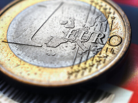 1 one euro coin lies on a bank plastic card. Focus on the name of the Eurozone currency. Close-up. Illustration with increased contrast and saturation about the economy of the European Union. Macro