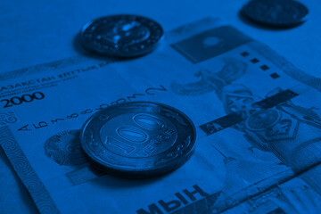 Kazakh money. A bill in 2000 tenge, a coin in 100 tenge and others. A coin of the sample of 2019 with inscriptions in Latin. Dark blue background or wallpaper about the economy and banks. Close-up