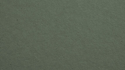 The surface of dark gray cardboard. Paper texture with cellulose fibers. Paperboard wallpaper or background with ebony tint. Textured glamorous backdrop. Top-down. Macro