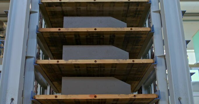 Close-up, a stacker loaded with concrete parts. Automated modern stacker in the factory warehouse, production logistics. 4k, ProRes
