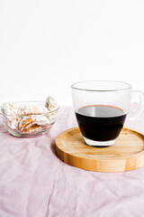 Buttery biscuit with icing sugar on top, and a cup of black coffee. Selective focus.