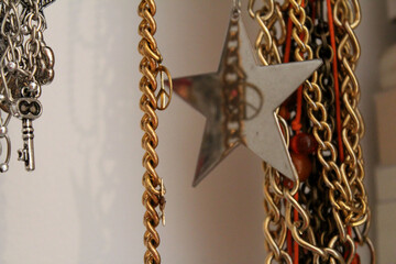 Primer plano de un collar plateado con un dije en forma de estrella, junto con m&aacute;s joyas.