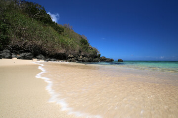 a sandy beach next to a body of water