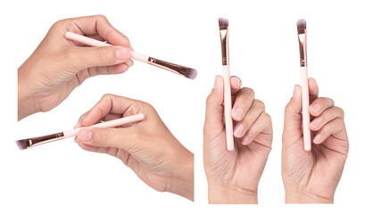 Set of hand holding makeup brushes isolated on white background.