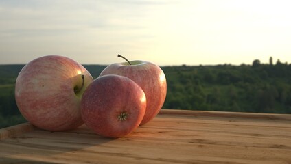 3d rendering of apples on a wooden board on a green forest background.