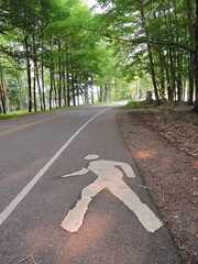 Pedestrian walking symbol on footpath through woods 