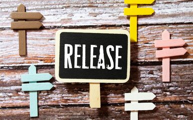 Wooden tag written new release over blue background