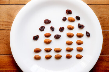 Top view of a plate with almonds and raisins simulating a bar and lines graph