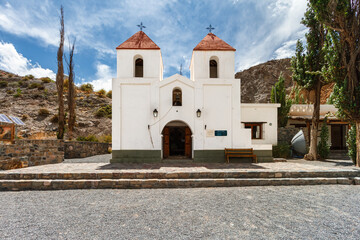 Fototapeta na wymiar Facade of Iglesia San Cayetano with hills in the background in El Alfarcito, Salta, Argentina