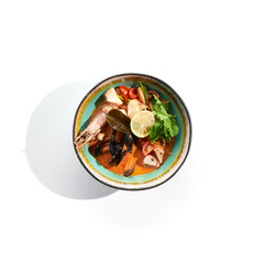 Tom yum or tom yam - hot and sour Thai soup with mixed seafood. Thai traditional soup with shrimps and coconut milk. Tom yum on white background. Isolated soup plate over white background. .