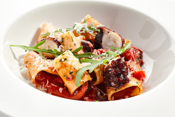 Cannelloni pasta with seafood and Parmesan cheese. Lasagna cannelloni pasta stuffed with tomato sauce and fried octopus. Italian pasta in white plate isolated on white background .