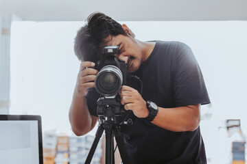 Male photographer taking a photo with a tripod - obrazy, fototapety, plakaty