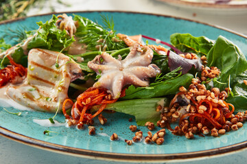 Seafood salad  with crispy buckwheat and mixed greens. Frutti di Mare salad with mixed seafood - salmon, calamari, octopus. Gourmet restaurant salad plate.