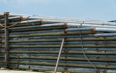 Many pipe steel stacked layers high with electric cable. For building construction in the outdoor.