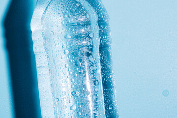 Pure drinking mineral water in a transparent plastic bottle on a blue background. 