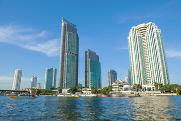 Modern high-rise buildings on the banks of the Chao Phraya river on a sunny day. Bangkok, Thailand