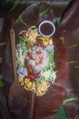 .Fried rice with shrimp paste served on banana leaves by the pool..red speckled banana leaves in the background..beautiful color of nature background. food and restaurant concept..