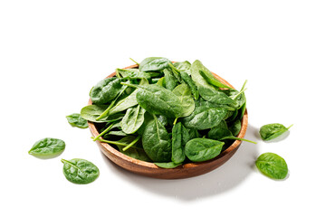 Fresh spinach leaves on wooden plate. Healthy vegan food.  isolated on white background. - obrazy, fototapety, plakaty