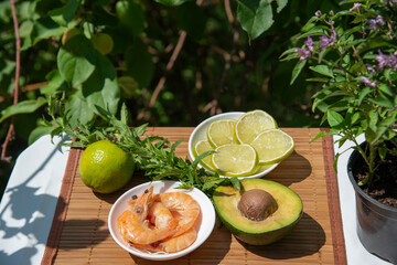 Shrimp, avocado and lemons on the table in the summer garden. The concept of healthy food. The Mediterranean diet.