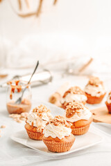 Muffin. Creme muffins with caramel and nuts. Creme on the top of muffin. Caramel muffins.  