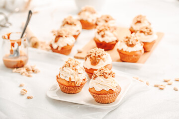 Muffin. Creme muffins with caramel and nuts. Creme on the top of muffin. Caramel muffins.  