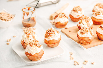 Muffin. Creme muffins with caramel and nuts. Creme on the top of muffin. Caramel muffins.  