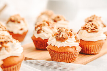 Muffin. Creme muffins with caramel and nuts. Creme on the top of muffin. Caramel muffins.  