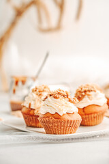 Muffin. Creme muffins with caramel and nuts. Creme on the top of muffin. Caramel muffins.  