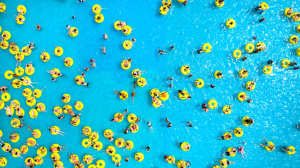 Top view of People relaxing in the pool on yellow inflatable circles